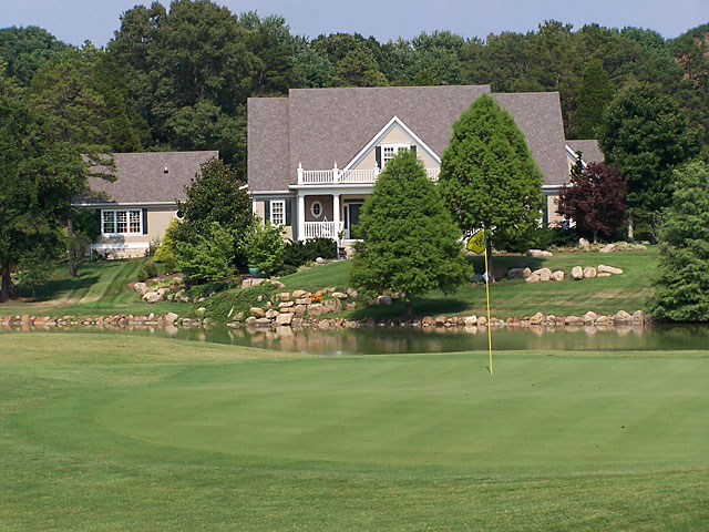 Fox Den home beyond green and water